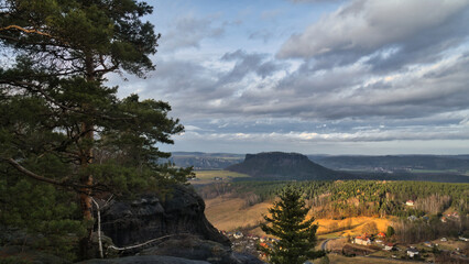 Sweeping view over a wooded valley with hills under a dramatic cloudy sky.