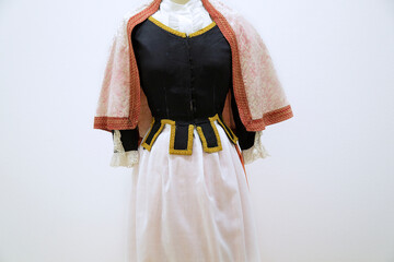 Traditional Menorcan pallesa costume with black bodice, lace blouse, white skirt, and pink shawl.