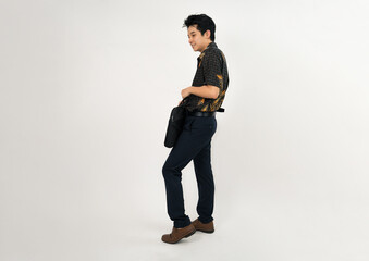 young professional with batik shirt holding briefcase in casual business attire