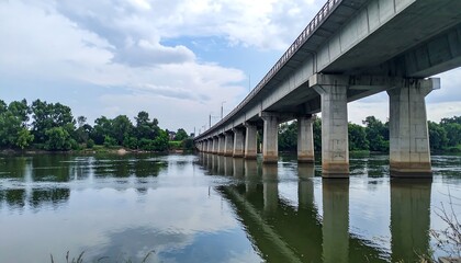 Fototapeta premium Concrete railway bridge cutting across river, calm and clean framing
