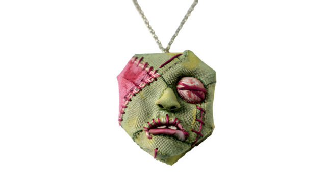 Unique stitched zombie face pendant necklace, a quirky accessory for bold fashion statements isolated on white background 