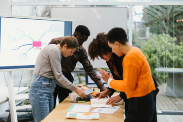 Diverse business team analyzing reports and brainstorming new strategies