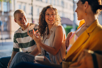 Friends enjoying a lively conversation in a sunny outdoor cafe setting during a relaxing afternoon