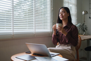 Businesswoman relaxing with coffee during work break at home office