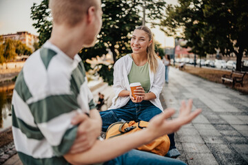 Students enjoying a casual conversation by the riverside during the late afternoon