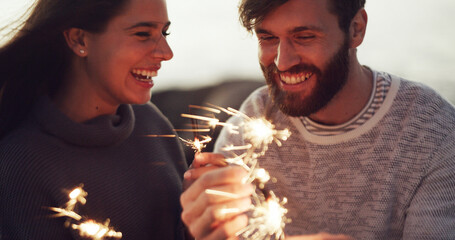 Happy couple, celebration and anniversary with sparklers for new year, outdoor party or memory. Man, woman or playing with fireworks, smile or moment for festive holiday, date or weekend together