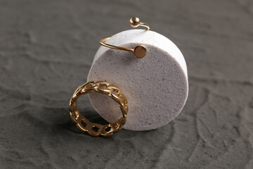 Decorative podium with beautiful rings on black background