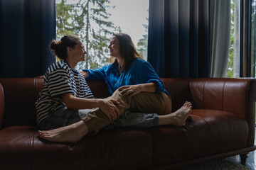 Lesbian couple enjoying time together on a sofa