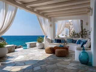 A white house with a blue ocean in the background. The house has a patio with a white roof and white curtains. There are several potted plants and vases on the patio
