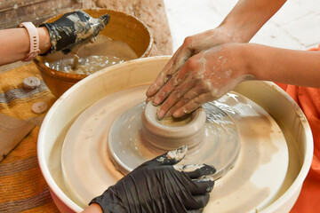 Hands in motion shaping clay on the potters wheel. Moment of creation at the wheel and ready...
