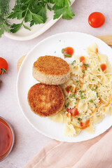 Plate of tasty meat cutlets with pasta on white background