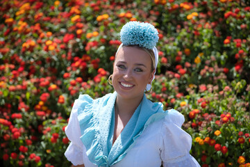 Portrait of young woman, beautiful, blonde, with typical Andalusian flamenco costume to go on...