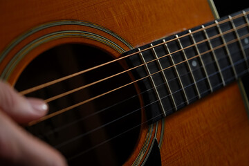 Fototapeta premium Close Up of an Acoustic Guitar with Strings and Fingerboard Being Played By a Person