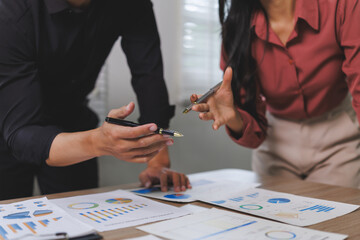 Fototapeta premium Business people analyzing financial charts and graphs at office desk