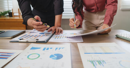 Business people analyzing financial charts and graphs at office desk