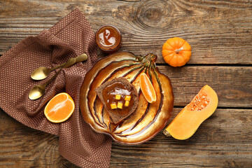 Plate of toast with sweet pumpkin jam and orange on wooden background