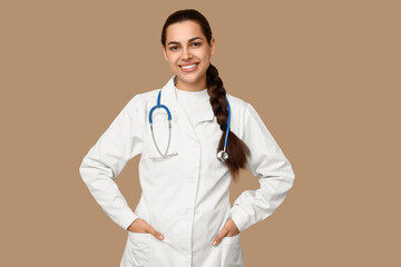 Portrait of female doctor with stethoscope on beige background