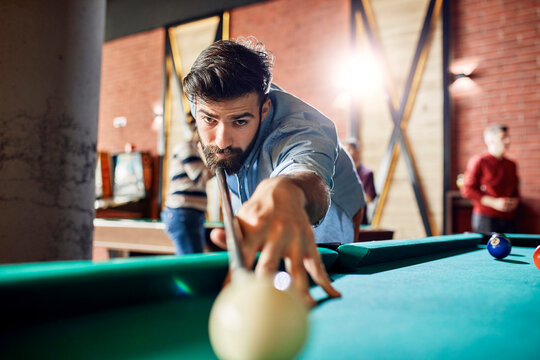 Porrait of focused man playing billiards