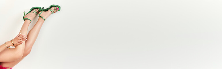 Elegant young woman showcases style in a stunning shoes in a bright studio