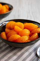 Organic Canned Mandarin Oranges in Bowls, side view. Close-up.