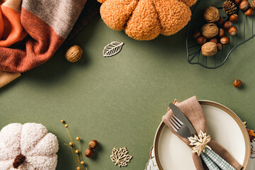 Autumn flat lay with plush pumpkins, striped plaid, nuts, and rustic table setting. Fall,...
