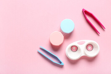Containers with contact lenses and tweezers on pink background