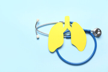 Yellow paper lungs and stethoscope on blue background