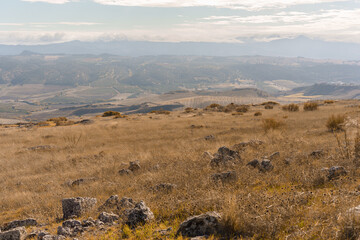 autumnal mountain landscape with the countryside full of dry thistles and stones from ancient ruins...