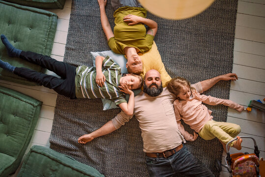 Family sleeping together on carpet at home