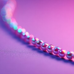 Iridescent pink pearls arranged in a gentle curve on a glittery purple surface. Soft lighting creates a dreamy atmosphere.
