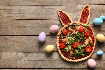 Composition with tasty pizza and eggs on wooden background. Easter celebration