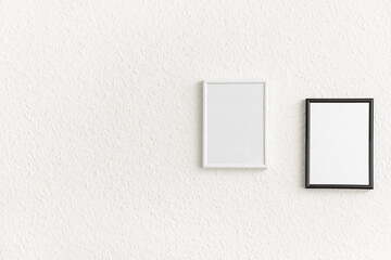 Photo frames hang on light wall