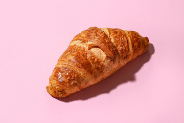 Tasty croissant on pink background