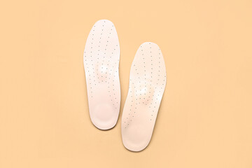 Leather orthopedic insoles on beige background