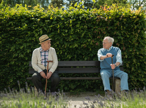Germany, Worms, Two old friends sitting on bench in park