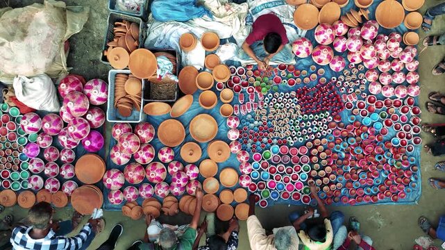 Bogura, Bangladesh - 17 August 2025: Aerial view of a vibrant pottery market displaying a kaleidoscope of colorful earthenware and terracotta products.