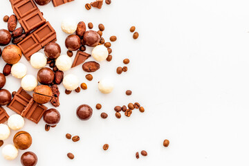 Chocolate background on white table top-down frame. Sweet desserts concept. Copy space