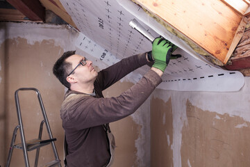 Roof insulation, worker fixing sarking membrane