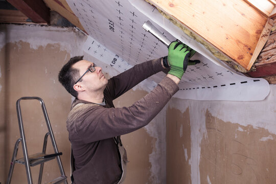 Roof insulation, worker fixing sarking membrane