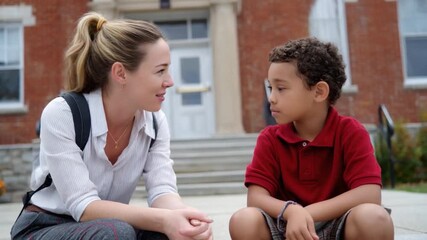 Schoolhouse Serenity: A heartwarming scene unfolds as a thoughtful teacher engages in an earnest conversation with a young student in front of a classic schoolhouse.