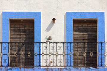 Traditional facade with iron balcony in blue and white color