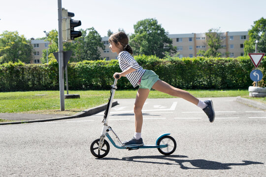 Girl riding push scooter on traffic course