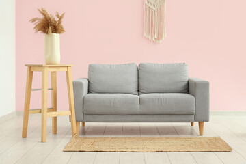 Cozy sofa with carpet and pampas grass in living room