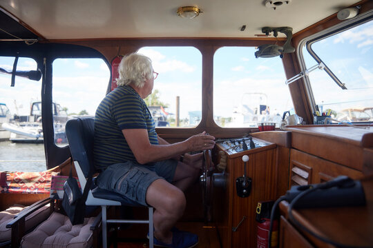 Senior man sailing boat sitting in cockpit on vacation