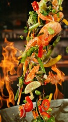 Freeze Motion of Wok Pan with Flying Ingredients in the Air and Fire Flames. Kitchen Interior on...