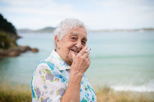 Portrait of smiling senior woman with cigarette