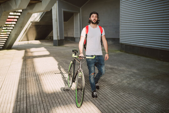 Young man walking with fixie bike
