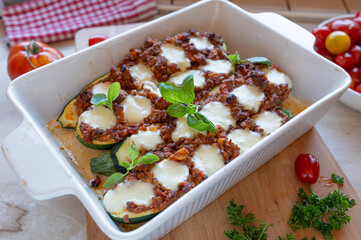Oven baked stuffed zucchini with minced meat and mozzarella cheese in a casserole dish