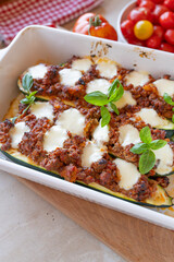 Oven baked stuffed zucchini with minced meat and mozzarella cheese in a casserole dish