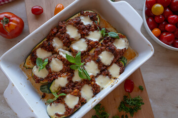 Oven baked stuffed zucchini with minced meat and mozzarella cheese in a casserole dish